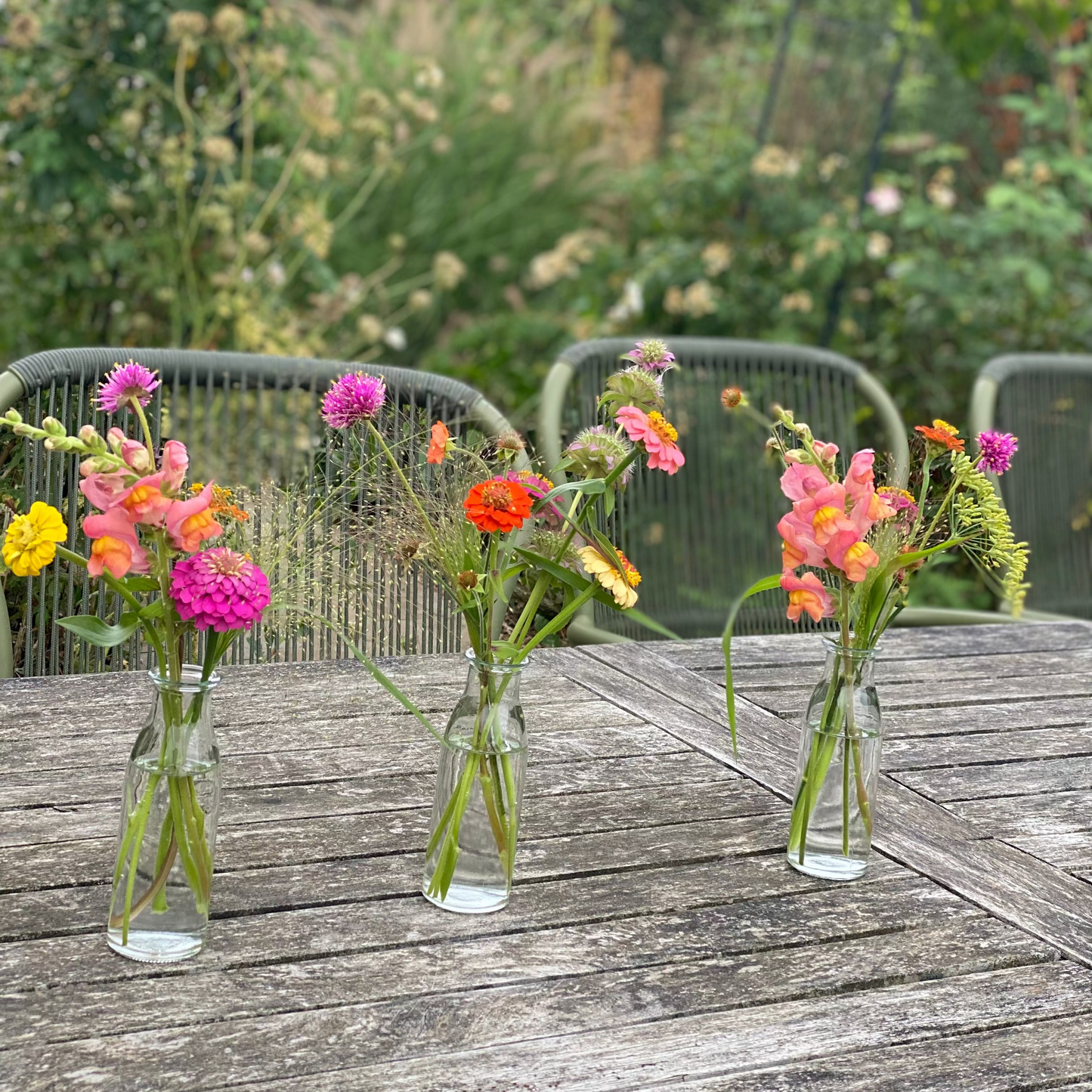 Gevulde tafelvaasjes met seizoensbloemen