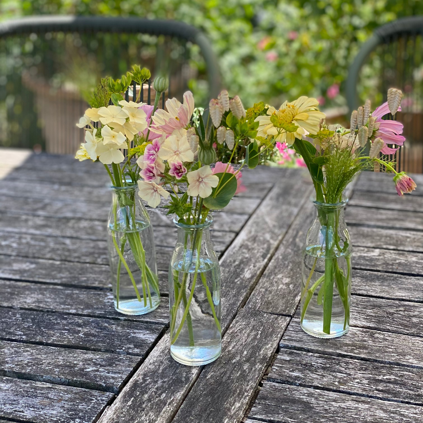 Gevulde tafelvaasjes met seizoensbloemen